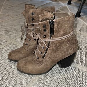 Tan heeled combat boots with zipper detail.